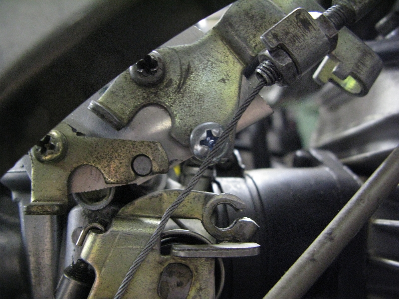 IMG_0123.JPG - Good shot of the adapter for the cable routing. Moved up and forward and tilted down Retains stock SRX cables. The extra piece of an original bracket on the lower left is to a) use the little locator peg sticking off the carb and b) put a throttle stop in the right place. That's the bit that sticks out of the picture toward the viewer.