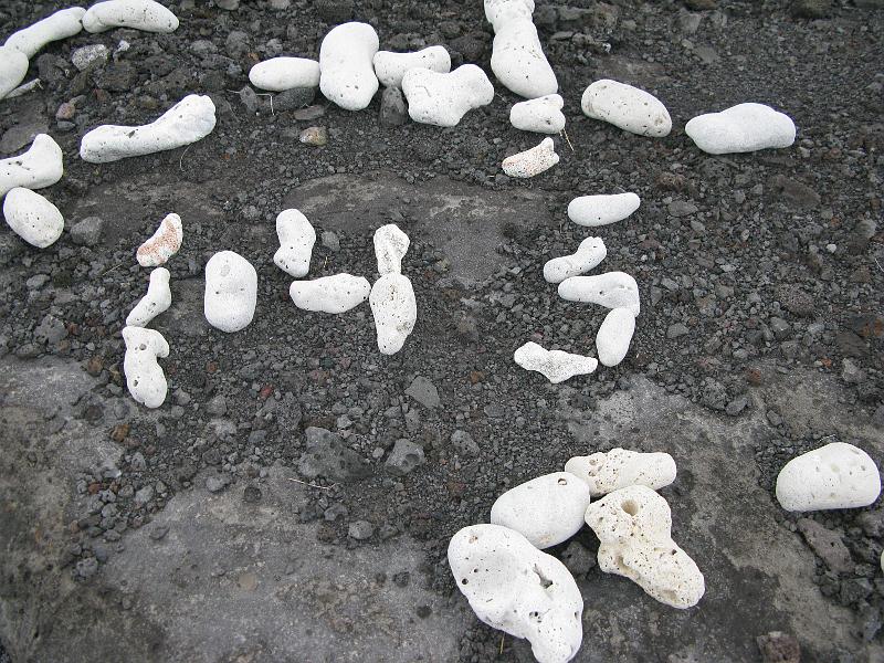 IMG_2117.JPG - Folks collect these white rocks and spell out messages on the darker lava, which is all you can see from the highway for miles and miles.